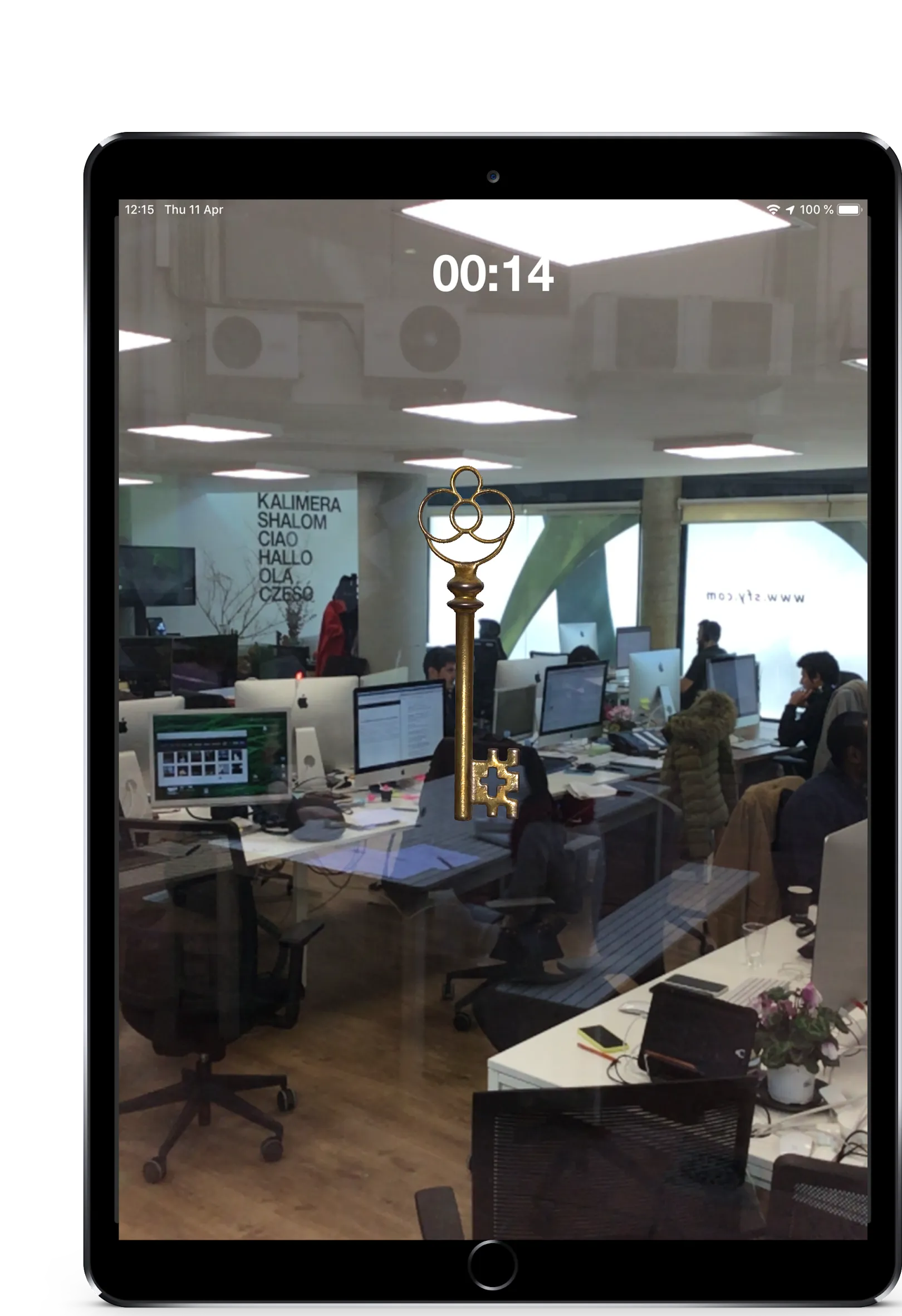 AR object pickup — a 3D golden key floating in an office environment, viewed through the device camera
